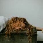 woman in white shirt lying on black textile